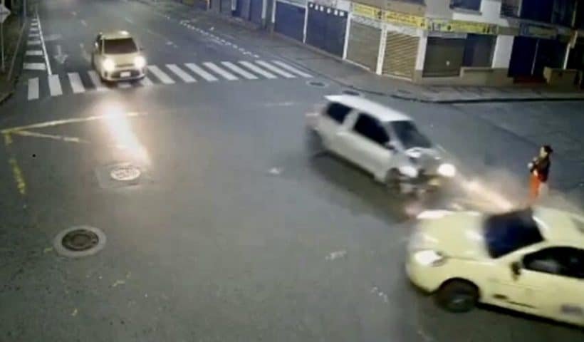 Los dos carros pasaron a mínimos centímetros de la mujer que esperaba cruzar la calle en toda la intercesión. ¡Vivió para contarlo!
